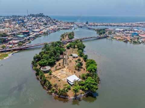Aerial view of Providence Island surrounded by the Mesurado River with a bridge connecting to the urban cityscape of Monrovia, Liberia.