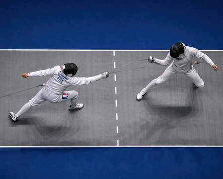 Two Fencers Competing in a Competitive Fencing Match