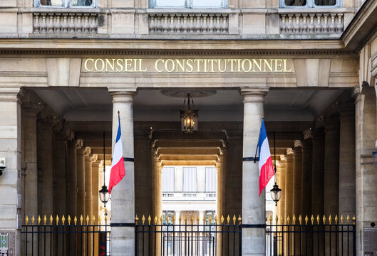 Paris, France - June 17, 2026: Front view of the portico decked with french flags at the entrance of the Constitutional Council, the highest constitutional authority, located in the Palais Royal.