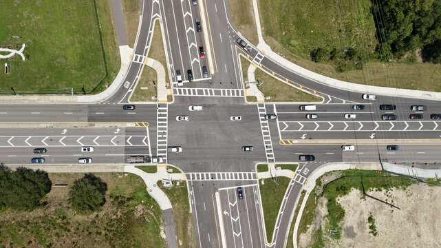 Aerial view of a busy highway intersection with multiple lanes, road markings, and vehicles traveling through the junction in the United States.
