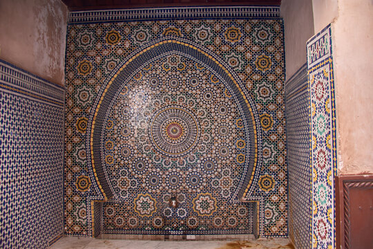 Details of the colorful geometric zellij mosaics on a traditional fountain in the Moroccan medina.