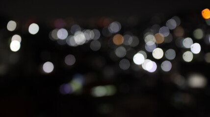 Fototapeta premium Blurred white and orange city lights create an abstract panoramic bokeh with cinematic mood, peaceful ambiance, and refined nighttime elegance.