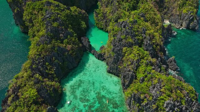 Aerial Orbit Right to Left Over Small Lagoon in El Nido, Philippines. Drone Cinematic Counter Clockwise Circular Flight Around Clear Turquoise Water and Limestone Cliffs.