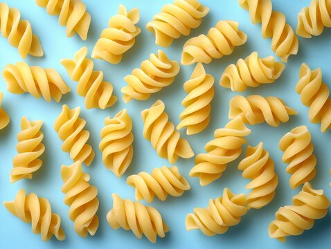 Uncooked rotini pasta displayed against a light blue background. Perfect for healthy cooking, food blog, or restaurant menu.