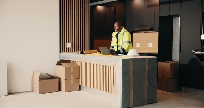 Laptop, planning and renovation with black man in kitchen for home improvement or upgrade project. Computer, property and writing with mature construction worker in apartment for real estate update
