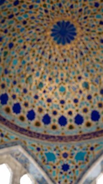 intricate arabesque mosaic dome interior with geometric patterns, blue and gold tiles, ornate Islamic architecture detail, spiritual atmosphere