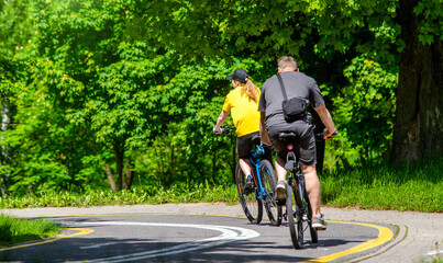 Fototapeta premium Cyclists ride on the bike path in the city Park 
