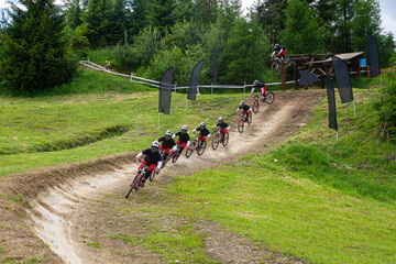 Mountain Biker Downhill Race Sequence on Forest Trail Showing Dynamic Jump and Cornering Action   Zdjęcie sekwencyjne z zawodów zjazdowych  (downhill) na leśnej trasie, ukazujące dynamiczny skok i pok © Adrian White