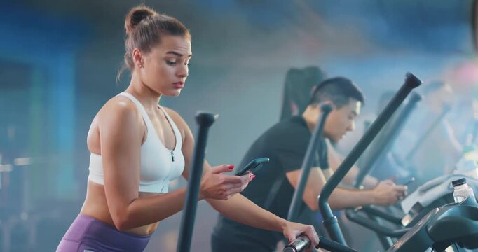 Engaged Workout Fitness Enthusiasts Actively Using Elliptical Machines for Better Health