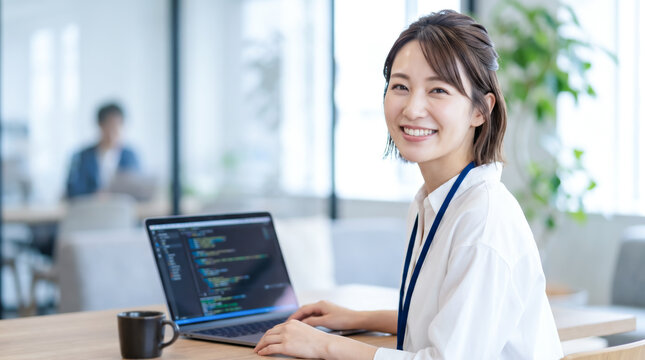 オフィスでパソコンに向かいプログラミングや開発業務をする女性システムエンジニア・SE