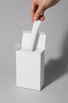 Hand Pulling Blank White Stick Pack Sachet from Paper Box Mockup