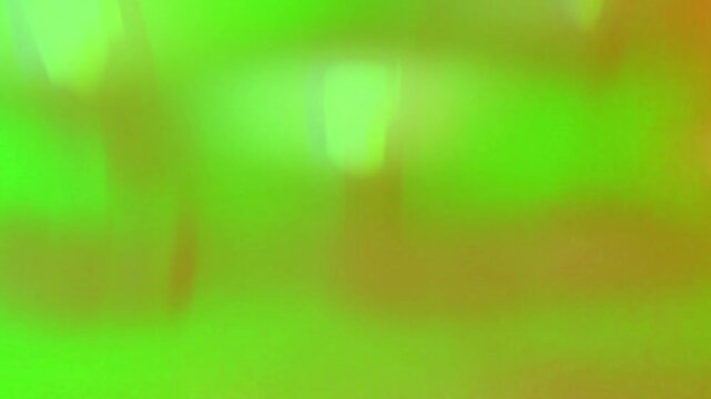 Abstract texture features a vibrant neon green surface with soft, diffused orange light leaks that bleed into the frame, creating an organic and fluid visual experience for contemporary digital media.