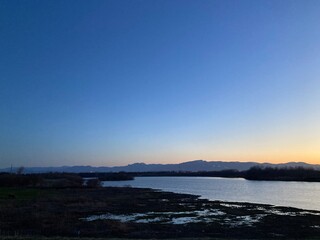 Obraz premium Peaceful Wetland at Twilight with Mountain Silhouettes