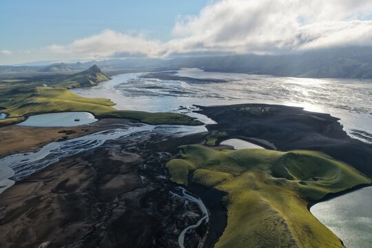 Aerial view of the volcanic landscape of Laki with moss-covered craters, dark volcanic sand, and glacial river channels in Kirkjubaejarklaustur, Skaftarhreppur, Iceland.