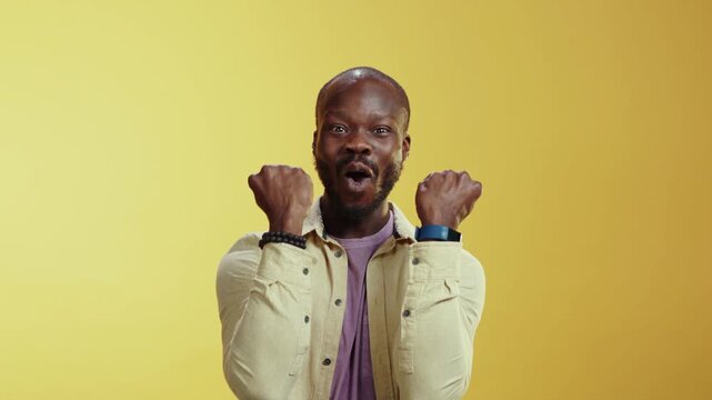 A man in white and purple shirts performs humorous skits and gestures