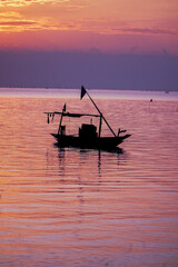 Obraz premium fishing boat at sunset