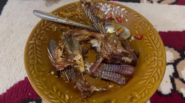 Leftover fish bone and head on a plate after a delicious Indonesian meal