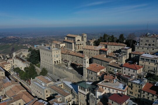 Aerial view of the historic city of San Marino, featuring the Basilica of Saint Marinus, Palazzo Pubblico, and traditional stone rooftops, San Marino, San Marino, San Marino.