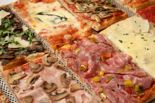 Des pizzas rectangulaires vari&eacute;es sur une table dans un restaurant