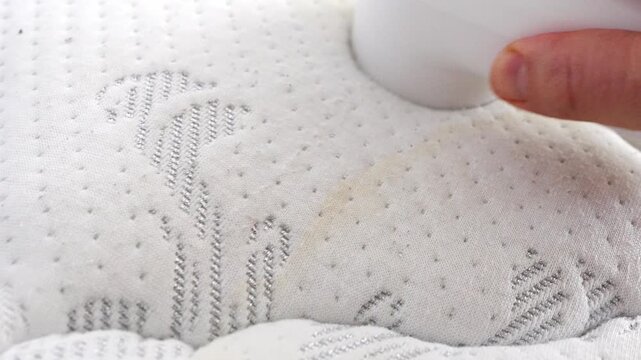 Removing fabric pills from a clean white mattress surface