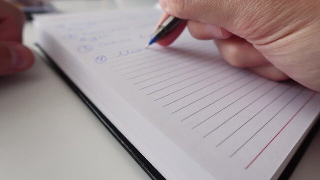 Hand Writing Notes in Notebook with Pen