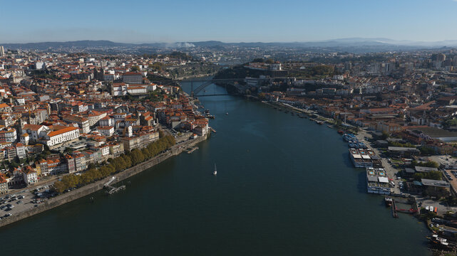 Aerial view of the historic city of Porto with the Douro River flowing through the urban landscape and the Dom Luis I Bridge in the background, Porto, Porto District, Portugal.
