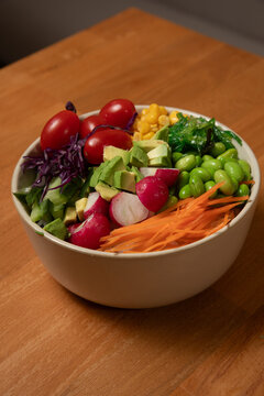 Salade poke bawl avec l&eacute;gumes frais sur une table en bois