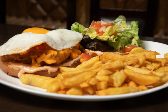 Plat de fritures avec &oelig;uf sur du pain et salade au restaurant