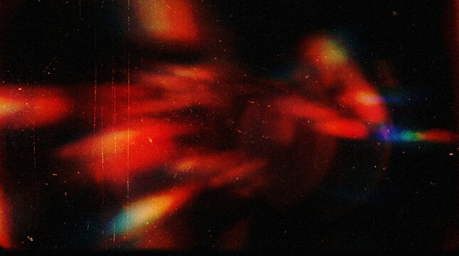 Grunge Background with Red Orange Light Leak Streaks, Rainbow Chromatic Aberration, Glowing Haze, Vertical Scratch Lines, Dust Particles and Distressed Texture Overlay on Dark Black
