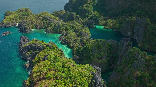 High Altitude Aerial View Backwards Over Small and Big Lagoon in El Nido, Philippines. Drone Pull Away Flight From Miniloc Island Limestone Cliffs toward Open Deep Blue Ocean.