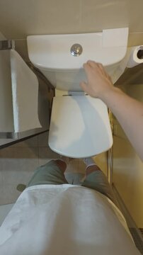 Point of view of man flushing toilet in bathroom