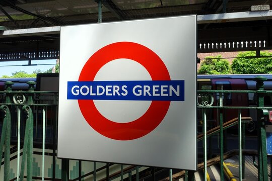 The sign for the London Underground at Golders Green station, on the Northern Line, showcases the traditional roundel design consisting of a red circle and blue bar against a white backdrop.