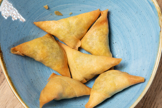 D&eacute;gustation de piments frits dans une assiette bleue sur une table en bois