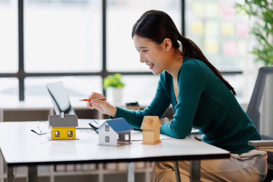 Real estate agent smiling while discussing property investment and home ownership options, analyzing market data for clients looking for a house