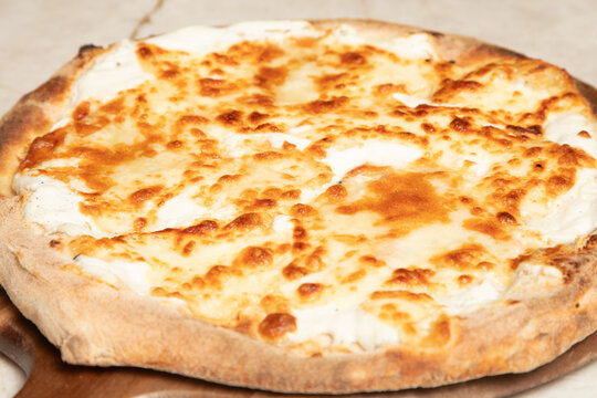 Pr&eacute;paration d'une pizza avec du fromage et une cro&ucirc;te dor&eacute;e