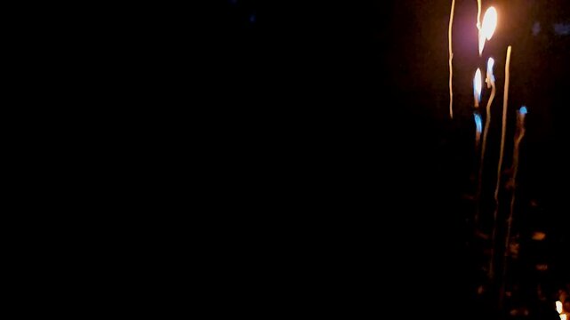 Abstract close-up footage of blue flames and swirling smoke rising from burning plastic against a deep black background. The flowing smoke creates dramatic organic patterns