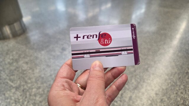 MADRID, SPAIN - JUNE, 22, 2026. Hand holding renfe commuter card closeup for madrid cercanias transit travel pass and public transport background for design