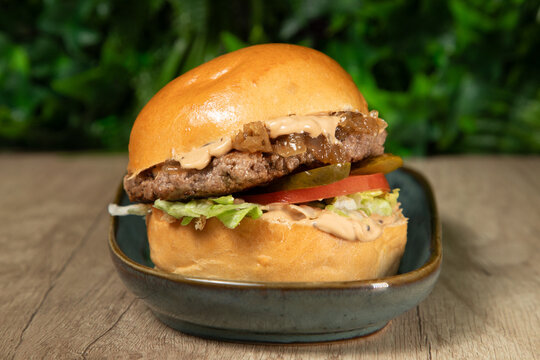 Un hamburger plac&eacute; sur une assiette avec des ingr&eacute;dients frais et une sauce