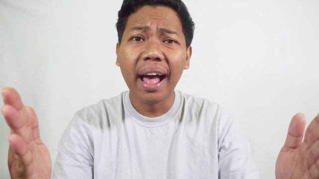 angry man raising hands and asking why wearing casual clothes isolated in studio