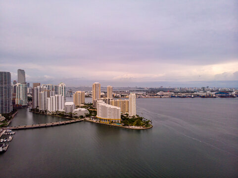 Miami, United States - 24 December 2019: Aerial view of the Miami skyline and Brickell Key surrounded by the calm waters of Biscayne Bay under a cloudy sky.