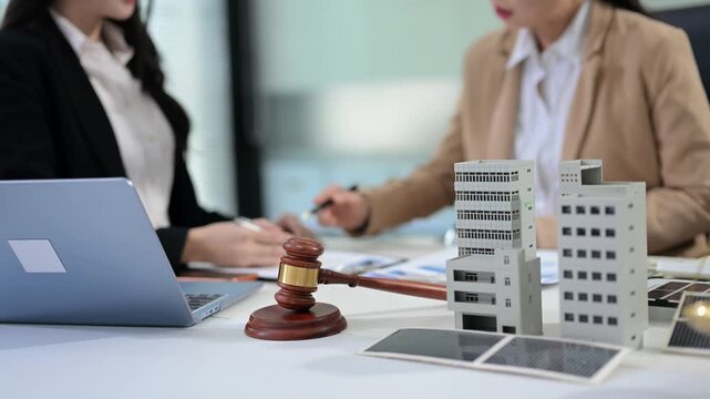 Business team consulting on real estate deal with building model, contract, and calculator. Ideal for property investment, legal agreement, and finance themes.