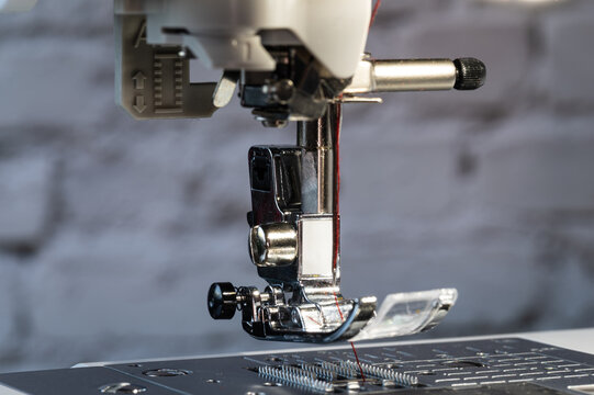 Sewing machine foot with needle at the top and carrier