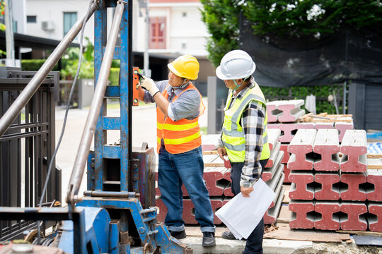 Calibrating construction machinery.A technician uses a spirit level to ensure the drilling rig is perfectly vertical before starting foundation piling work.