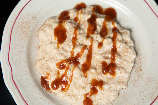 Riz au lait avec du caramel servi dans une assiette blanche