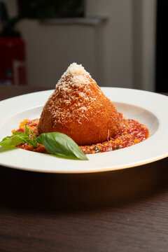 Desserte avec une sculpture de riz sur une sauce rouge et des feuilles de basilic