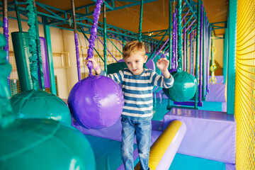 Obraz premium Boy balancing on obstacle course in indoor playground