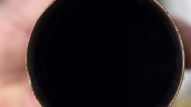 Extreme close up of an angle grinder abrasive disc on a rusty metal pipe