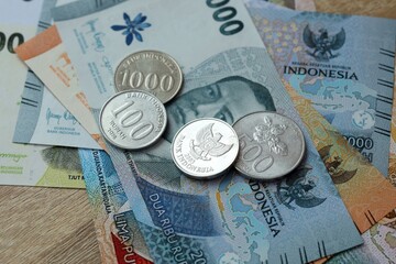Indonesian rupiah money bills and coins on table. Indonesia cash of IDR currency © Larysa