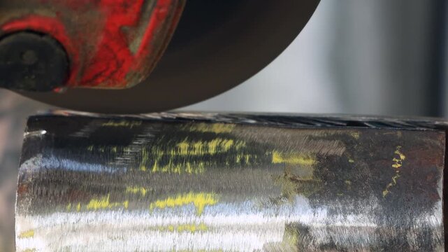 Extreme close up of an angle grinder cutting disc touching a metal pipe