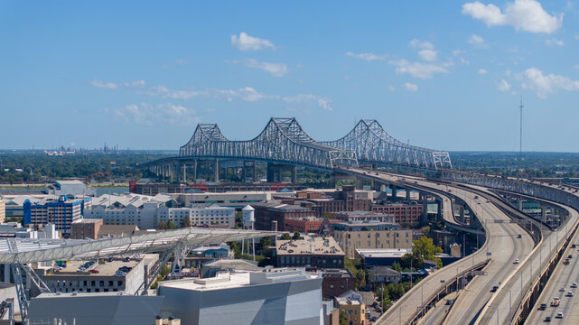 New Orleans, United States - 24 October 2025: Aerial view of the Crescent City Connection bridge spanning the Mississippi River with urban infrastructure and highways in the foreground.